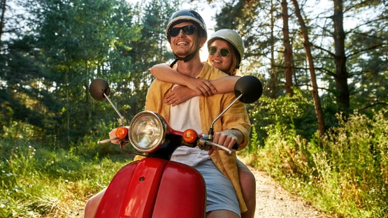 Zwei Personen fahren sorglos Roller, da sie diesen ordnungsgemäß angemeldet haben.