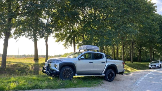 Mitsubishi L200 Pickup parkt am Seitenrand einer Landstraße