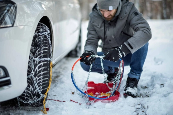 Mann montiert Schneeketten