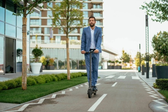 Ein Mann fährt unbeschwert mit seinem E-Scooter, dank Versicherung. 