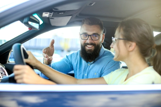 junge Frau wird von Mann im Auto begleitet