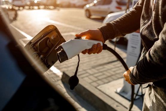 Person laed ein Fahrzeug mit Elektrostrom auf