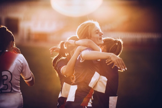 Junge Frauen spielen Fussball und freuen sich