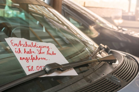 Frau mit Schrammen am Auto