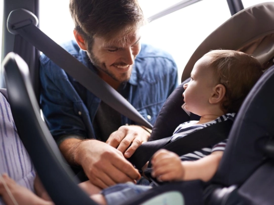Vater schnallt sein Baby an