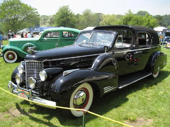 Schwarzer Oldtimer-Luxuswagen aus den 1930ern auf Autoschau, Vintage-Auto mit Whitewall-Reifen im Grünen