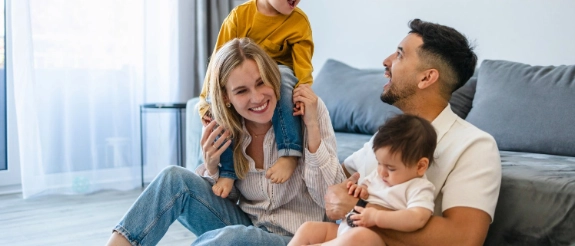Ein Paar mit Kindern freut sich, denn sie sind durch Versicherungen für Familien gut abgesichert.