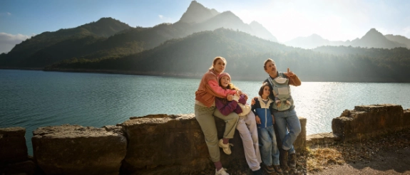 Eine Familie genießt ihren Urlaub in den Bergen, abgesichert durch eine Auslandsreisekrankenversicherung.