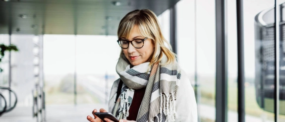Frau mit Smartphone und Laptop