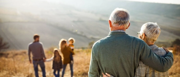  Ein älteres Paar, welches auf seine weggehende Familie/Jüngere Generation schaut.