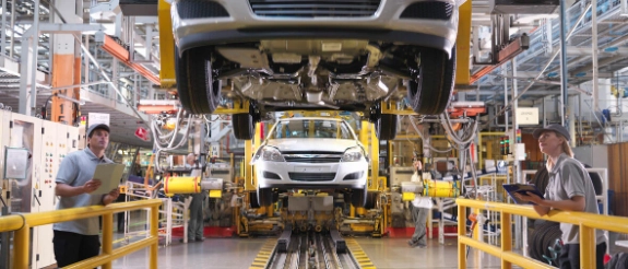 Fahrzeugrückruf: Mitarbeiter inspizieren Auto in Produktionslinie
