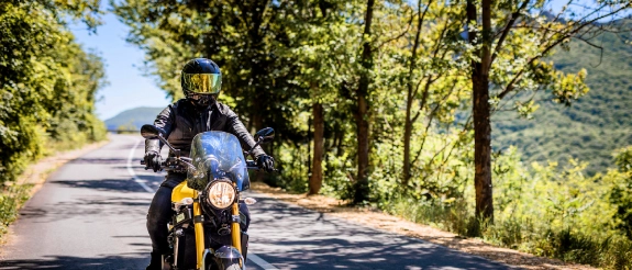 Motorradfahrer fährt unbeschwert auf seinem Leichtkraftrad dank der 125er-Versicherung.