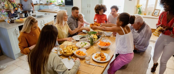 Menschen einer Verantwortungsgemeinschaft sitzen am Tisch und essen gemeinsam.