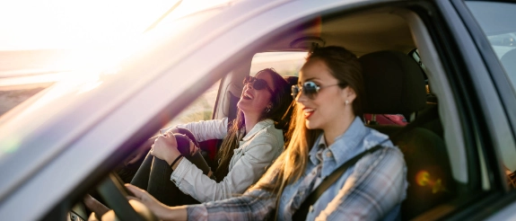 Zwei junge Frauen unterwegs im Auto.
