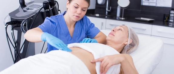 Ärztin untersucht ältere Patientin mit Ultraschallgerät im Behandlungszimmer