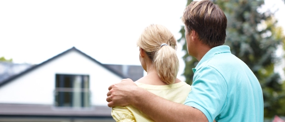 Mann und Kind blicken auf Einfamilienhaus, Familie vor eigenem Haus, Immobilienerwerb und Heimat