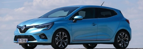 Blauer Renault Clio in der Seitenansicht auf grauem Untergrund mit bewölktem Himmel