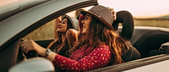 Zwei Frauen machen eine Spritztour im Cabrio.