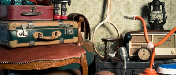 Vintage Koffer, Lederhandschuhe, tragbarer Ventilator, Laterne und Retro-Gegenstände auf Holztisch arrangiert