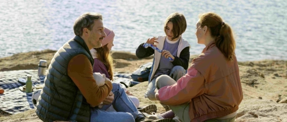 Eine Familie erklärt ihren Kindern die Vorteile einer Altersvorsorge.