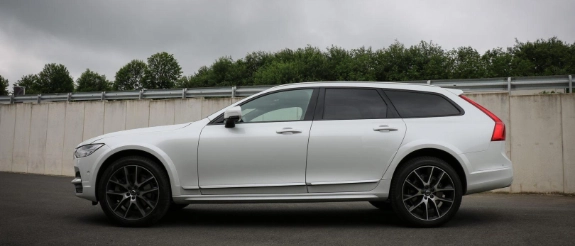 Weißer Volvo XC90 SUV steht auf Parkplatz bei bewölktem Himmel, Seitenansicht