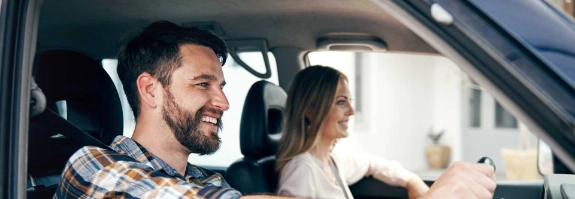 Zwei glückliche Personen im Auto.