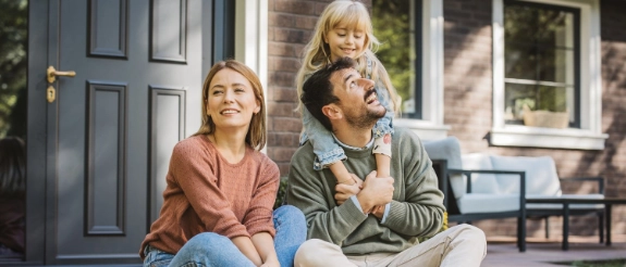 Eine Familie vor ihrem Haus freut sich über das Lösen von Rechtsstreitigkeiten durch den R+V Immobilien-Rechtsschutz.