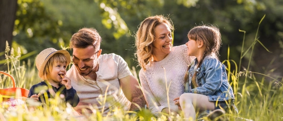 Eine fröhliche Familie macht ein Picknick auf der Wiese.