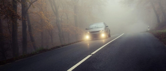 Auto fährt durch den Nebel.