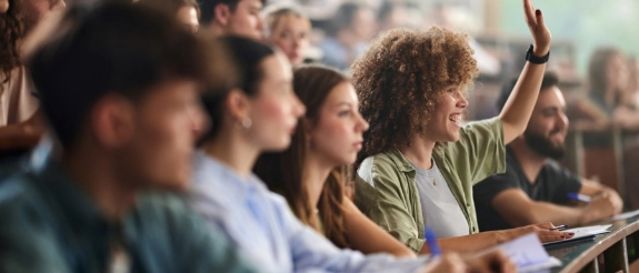 Studentin meldet sich im Vorlesungssaal  