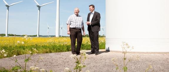 Zwei Geschäftspartner in einem Windpark.