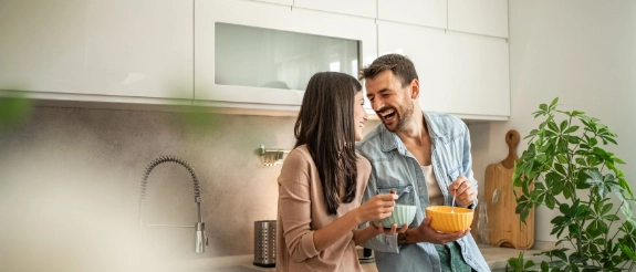 Eine Frau und ein Mann genießen ihr Frühstück in der Wohnung.