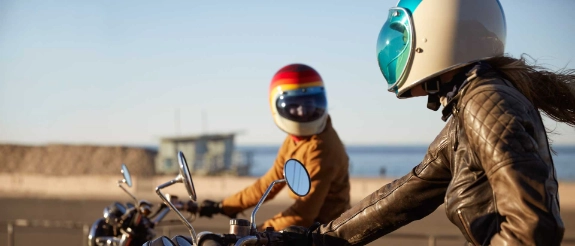 Zwei Personen auf Motorrädern unterhalten sich zu den Kosten des Motorradführerscheins.
