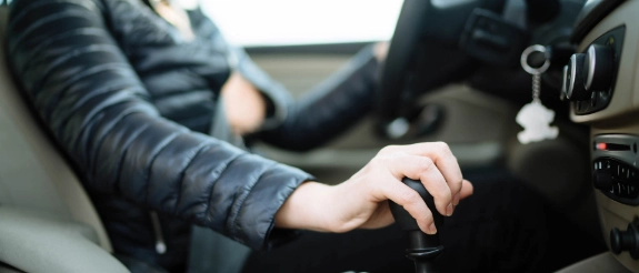 Person bedient die Gangschaltung im Auto.