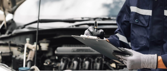 Kfz-Mechaniker in einer Werkstatt mit Checkliste