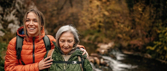 Eine junge Frau geht mit ihrer Großmutter wandern.