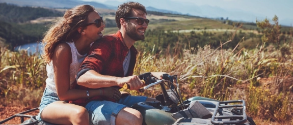 Eine Frau und ein Mann können die Fahrt auf ihrem Quad genießen, weil sie durch eine Versicherung gut abgesichert sind.