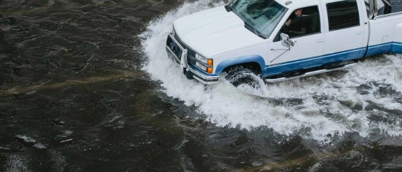 Auto fährt durch Hochwasser