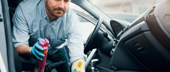 Mann reinigt Autositze.