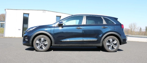 Blauer SUV mit offener Heckklappe auf Parkplatz, modernes Elektrofahrzeug in Seitenansicht