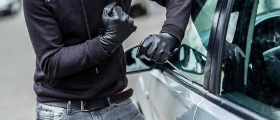 Dieb bricht Auto auf.