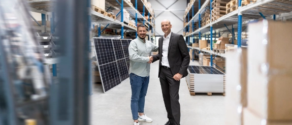 zwei Personen stehen gemeinsam in einem Lager für Solar- und umweltfreundliche Energieranlagen