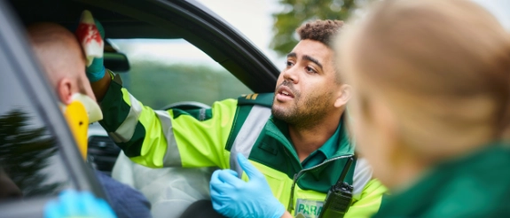 Einsatzkräfte in Warnwesten führen Atemalkoholtests bei Verkehrskontrolle durch
