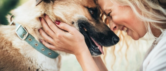 Eine Frau teilt einen glücklichen Moment mit ihrem Hund.