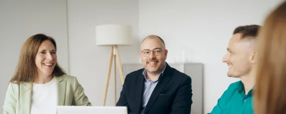 Vertriebsmitarbeiterinnen und Vertriebsmitarbeiter in einer Beratungssituation.