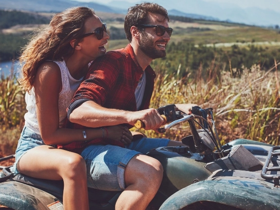 Eine Frau und ein Mann können die Fahrt auf ihrem Quad genießen, weil sie durch eine Versicherung gut abgesichert sind.