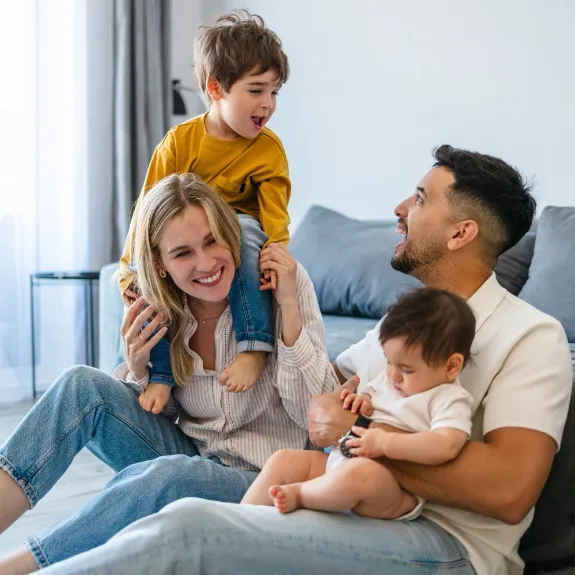 Ein Paar mit Kindern freut sich, denn sie sind durch Versicherungen für Familien gut abgesichert.