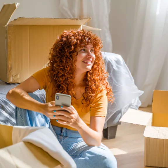 Junge Frau sitzt entspannt in ihrem Zimmer nach dem Abschluss eines Untermietvertrags