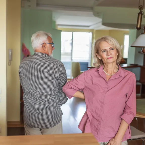 Ein aelterer Mann fuehrt eine ernsthafte Debatte mit seiner Frau