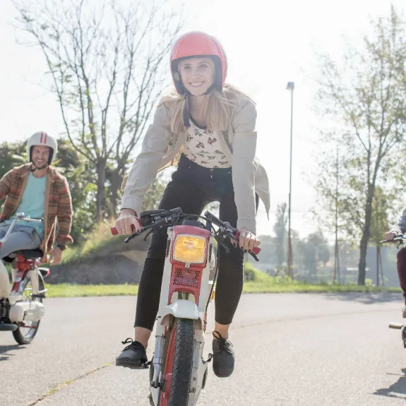 3 junge Leute fahren bei schönem Wetter auf ihren Mofas.